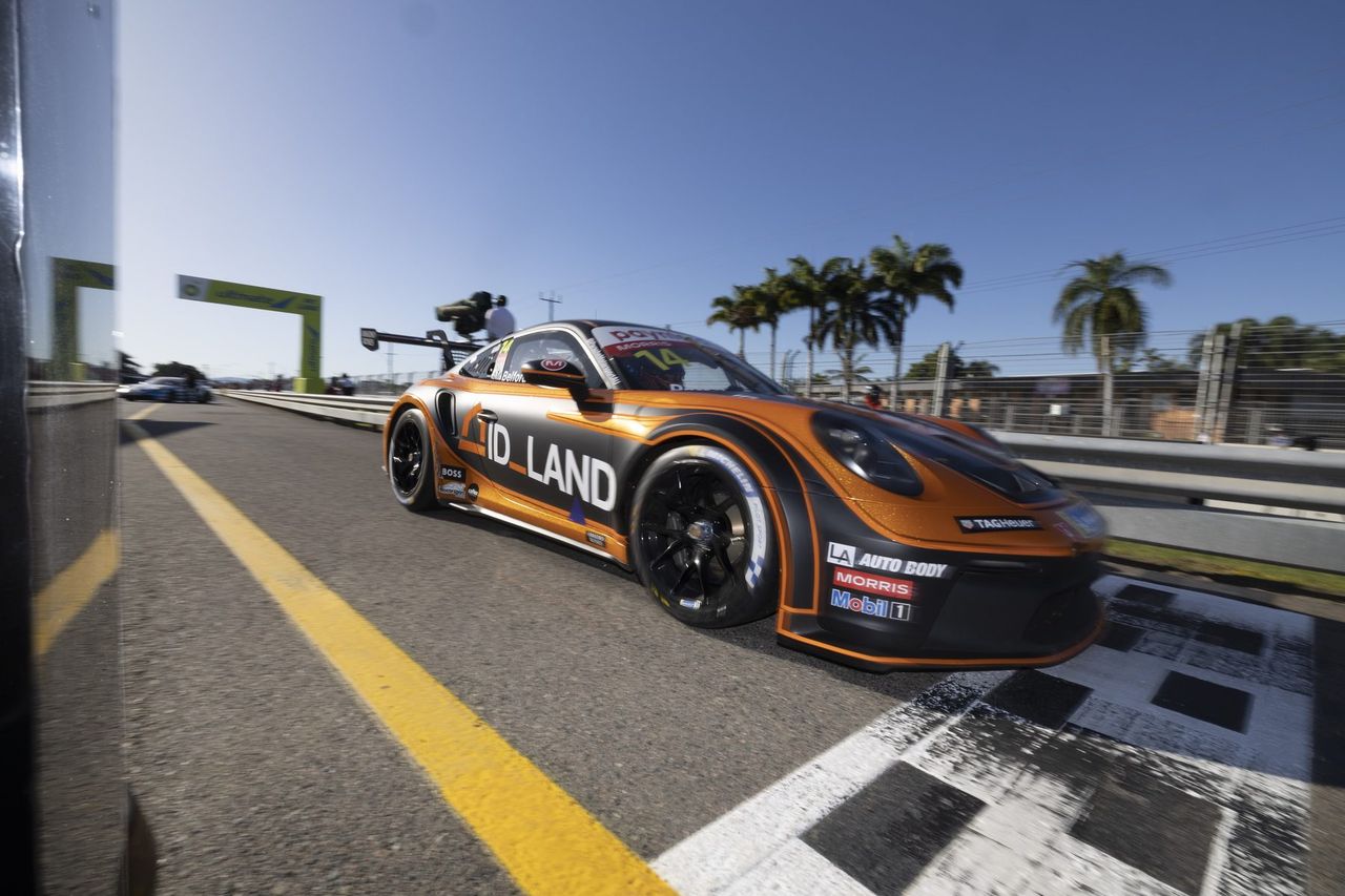 Porsche 911 GT3 Cup race car number 14 in an orange and black livery, leaving pit lane